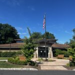 The exterior of Fairfield Public Library, with an American flag in a courtyard out front.